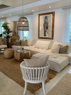 a living room filled with lots of furniture and large windows in the wall behind it