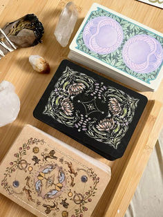 three decorative items sitting on top of a wooden table next to crystal rocks and stones