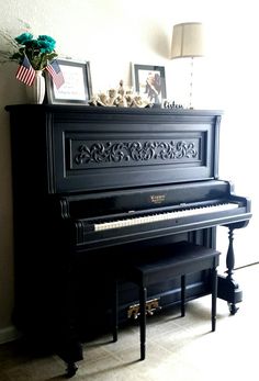 a black piano sitting in the corner of a room