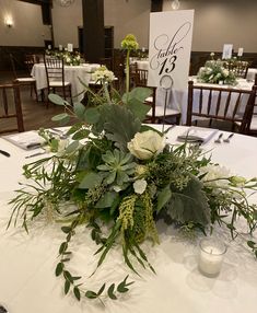 the centerpieces on the table are arranged with flowers and greenery