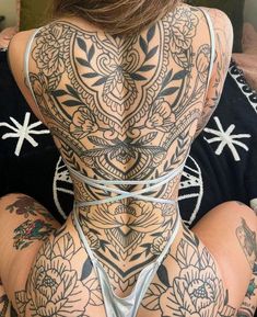 the back of a woman with tattoos on her body