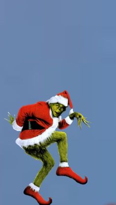 the grinch is flying through the air in his santa suit