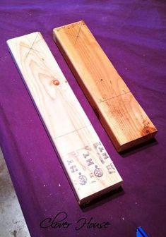 two pieces of wood sitting on top of a purple cloth covered floor next to each other