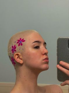 a woman with pink flowers painted on her head is taking a selfie in front of a mirror