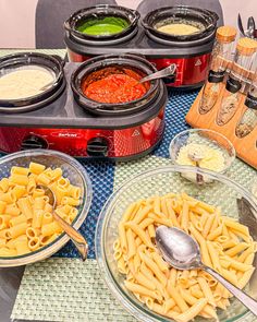 several different types of pasta in bowls on a table with utensils and seasonings