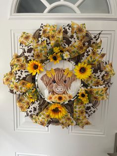 a wreath with sunflowers and a cow on it hanging from the front door