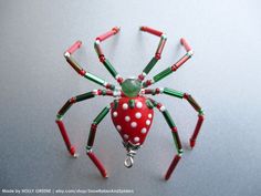 a red and green spider figurine with white dots on it's legs