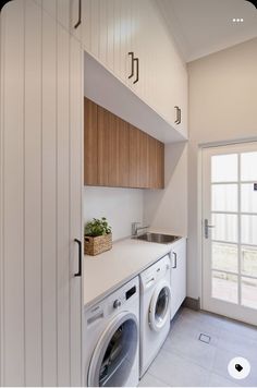 a washer and dryer in a small room with white tile flooring on the walls