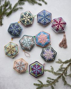 a bunch of ornaments that are sitting on a table next to some fir tree branches