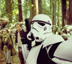 a group of people dressed up as stormtroopers in the woods with trees behind them