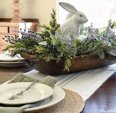 a dining room table set with plates and place settings for easter bunny figurines