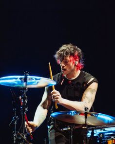 a man with red hair playing drums on stage