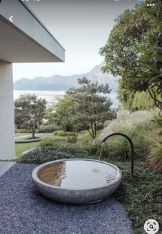 a bowl shaped water fountain in front of a building