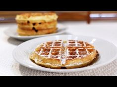 two plates with waffles on them sitting on a table