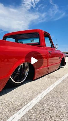 an old red truck is parked on the side of the road with its hood up