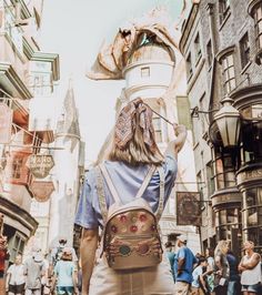 a person walking down a street with a backpack on their back and people in the background