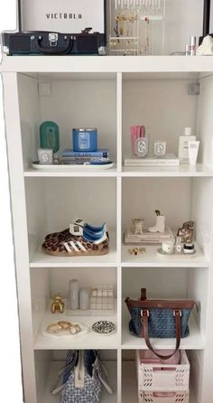 a white book shelf filled with purses and other items