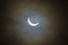 the moon is seen through the clouds during a solar eclipse