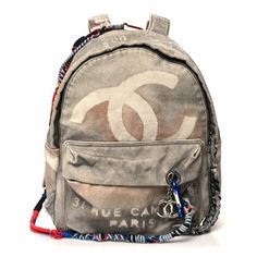 This is the authentic CHANEL Graffiti Printed Canvas Medium Backpack in Grey. This iconic backpack is crafted of grey canvas with a distressed effect, with CC logos throughout and a "31 Rue Cambon" graffiti print. It featuresmulticolored ropes and carabiner clips, a brown leather top handle, and an external zipper pocket.The top zipper opens with an oversized braided zipper pull to a grey fabric interior with a zipper pocket. Mochila Chanel, Chanel Graffiti, 1stdibs Chanel, Graffiti Backpack, Mint Backpack, Pochette Louis Vuitton, Chanel Beige, Chanel Art, Braided Bag