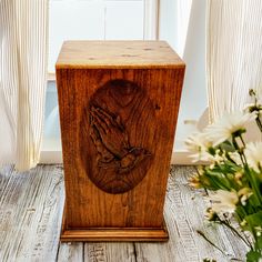 a wooden box with a praying hand on it