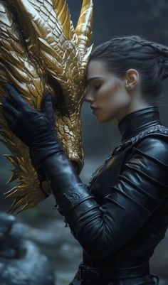 a woman in black gloves holding a golden dragon head with her hands and looking down at it