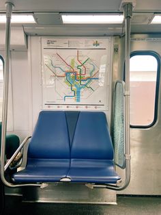 a subway car with blue seats and a map on the wall