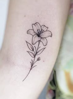 a small flower tattoo on the arm