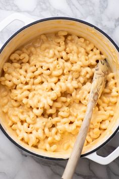 macaroni and cheese in a pot with a wooden spoon