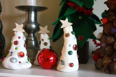 three small christmas trees sitting on top of a shelf