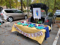 a table that has some food on it in front of a car with the trunk open