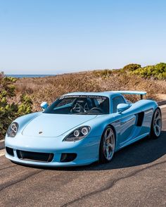 a blue sports car driving down the road