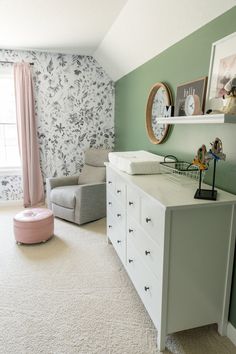 a baby's room with floral wallpaper and white carpeted flooring is shown