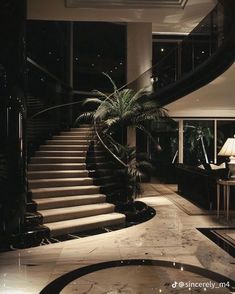 a large staircase in the middle of a living room next to a table and lamp