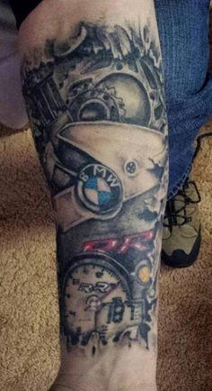 a man's foot with a clock and helmet tattoo on his left calf leg