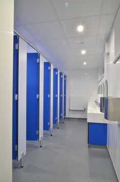 a row of blue and white storage units in a room with mirrors on the wall