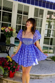 a woman in a blue dress standing on steps