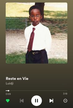 an image of a young boy wearing glasses and a tie with the caption reste en viie ludii