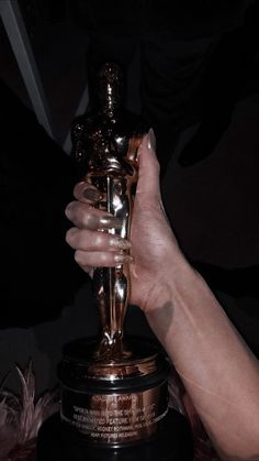 a person holding an oscar statue in their hand