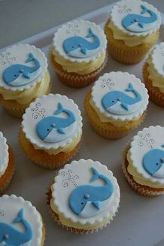 cupcakes with blue frosting and white icing are arranged on a plate