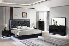 a modern bedroom with white walls and black furniture, including a large bed in the center