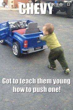 a baby pushing a toy truck with the caption, got to teach them young how to push one