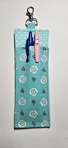 two toothbrushes are in a holder on a white surface with blue and green designs