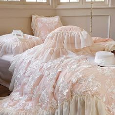 a bed with pink comforters and pillows in a room