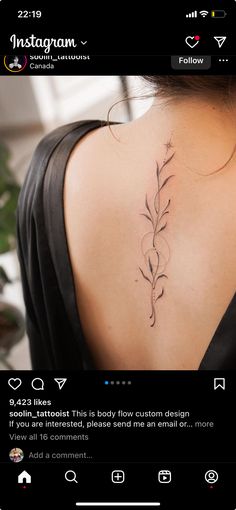 the back of a woman's neck with a vine tattoo on her left shoulder