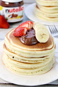 a stack of pancakes with chocolate sauce and sliced bananas