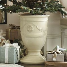 a potted christmas tree sitting on top of a table next to boxes and presents