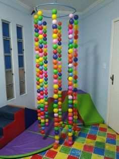 an indoor play area with colorful balls hanging from the ceiling