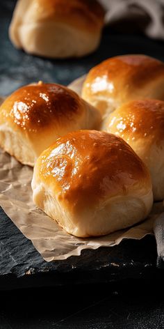 four rolls sitting on top of a piece of wax paper