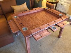 a coffee table made out of wood with metal bowls on it's bottom shelf