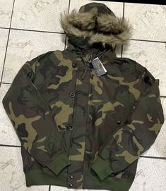 This Polo Ralph Lauren jacket for men is a colorful camo puffer with a hood. It is made of faux fur and has a zip-up design. The jacket is size L and is perfect for regular size types. The outer shell material is made of high-quality material that is sure to keep you warm during the colder months. The jacket is brand new and has never been worn before. It features a camouflage pattern that gives it a unique look. The jacket can be worn for different occasions and can be paired with different outfits to create a stylish look. The jacket is a great addition to any man's wardrobe. Polo Ralph Lauren Jacket, Team Jackets, Ralph Lauren Jacket, Jacket For Men, Men's Wardrobe, Zip Up Jacket, Zip Up, Vest Jacket, Camouflage